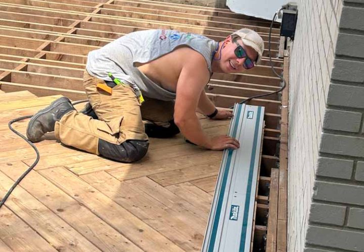 Overview of a deck construction site showing the wooden framework and partially installed wooden planks, capturing the progress in an outdoor building project.
