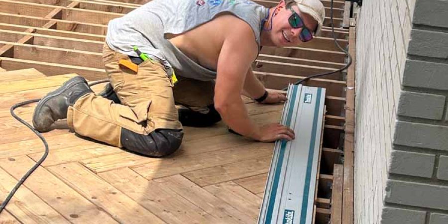 Overview of a deck construction site showing the wooden framework and partially installed wooden planks, capturing the progress in an outdoor building project.